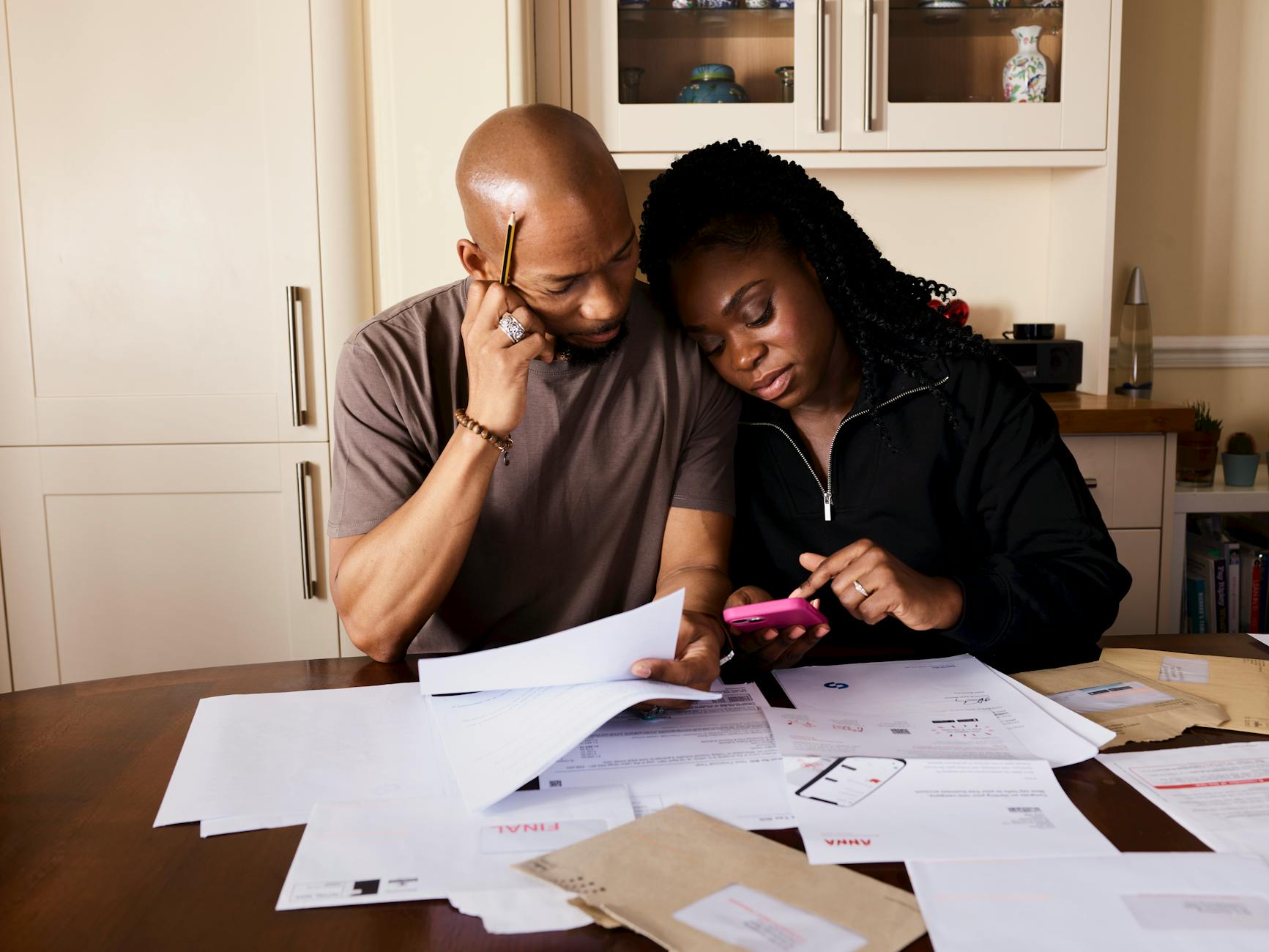 Couple reviewing financial documents at their dining table